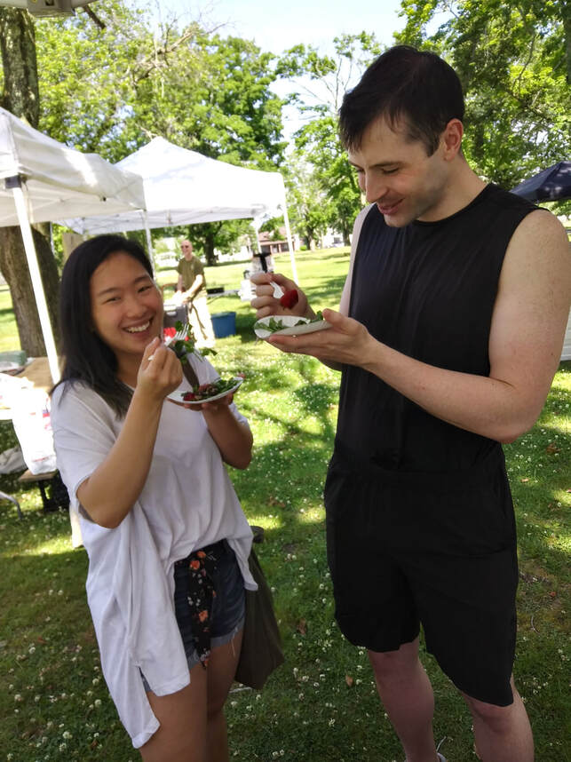 Market visitors tasting the strawberry salad